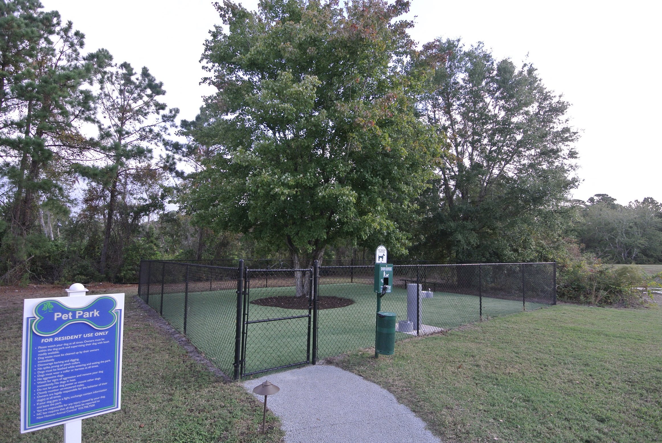 Pet Friendly Apartments in Wilmington, NC - Myrtle Landing Outdoor, Gated Pet Park with Water Fountain Surrounded by Trees